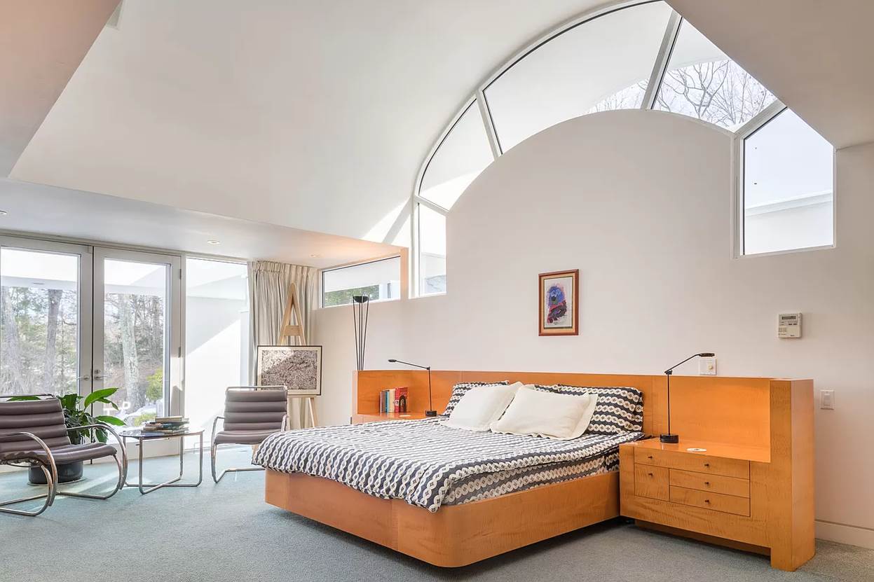 A bedroom with a bed and a chair
